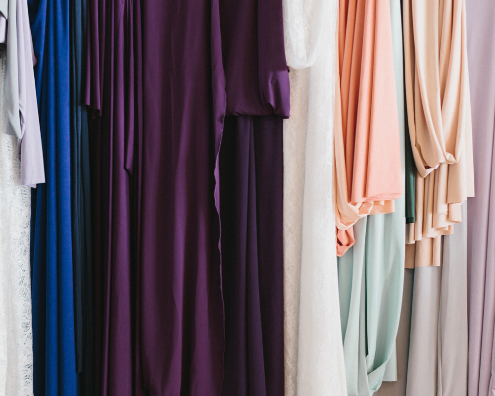 A photo shows multiple colours of fabric draped over a clothing rack